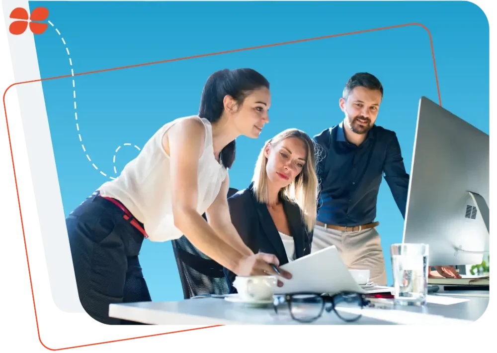 Trois professionnels en réunion autour d’un ordinateur, illustrant l’accompagnement complet dans la sous-traitance de la paie.