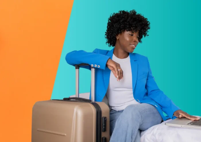 Collaborateur préparant un voyage d'affaires, entre valise et ordinateur portable