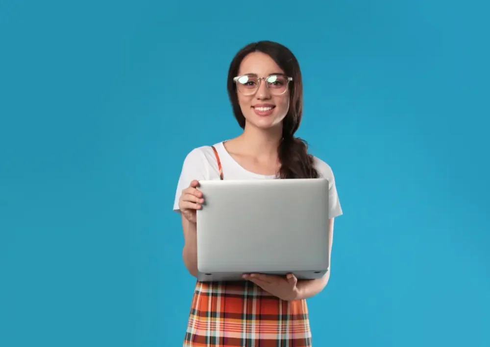 Jeune femme tenant un ordinateur portable, symbolisant un stage en entreprise.