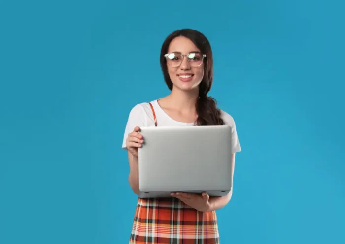 Jeune femme tenant un ordinateur portable, symbolisant un stage en entreprise.